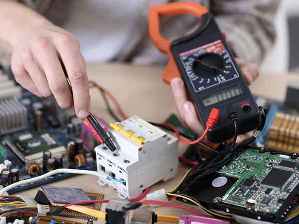 Young man measuring voltage in service center Indagini-strumentali-modena